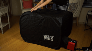 a animated gif of a lady loading the ZappBug Oven 2 with a nightstand and carry on luggage
