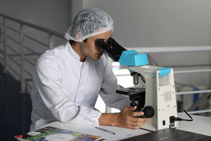Researcher looking into a microscope 